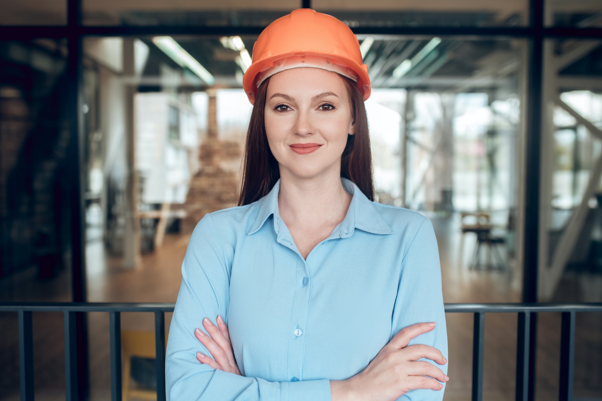 Optimistic young woman in safety helmet